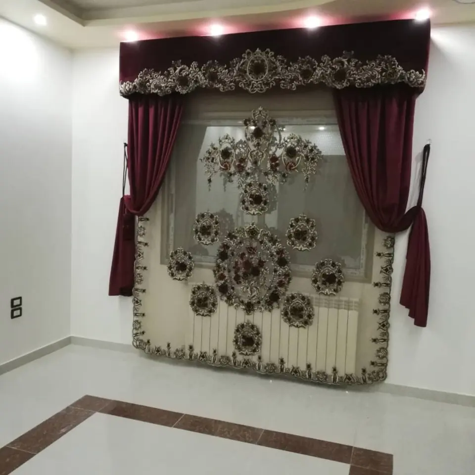 Burgundy velvet curtain with an embroidered valance and a sheer with large embroidered medallions